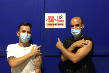 Jóvenes bromean con la cartelería del estadio, situada en su box de vacunación.