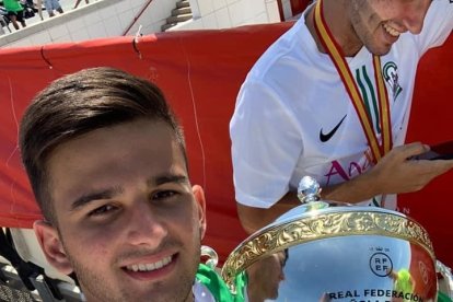 Con la copa de campeones.