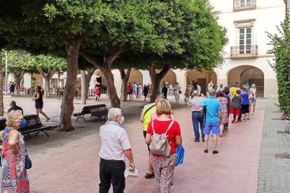 Colas en la segunda jornada del reparto de abanicos de Feria.
