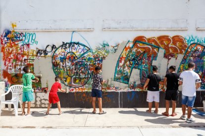 Jóvenes de El Puche realizando un grafiti con la palabra Cambio.