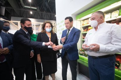 Juanma Moreno anima al presidente de la Diputación a probar uno de los productos en Fruit Attraction.