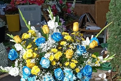 Detalle de un centro de flores con rosas azules y amarillas