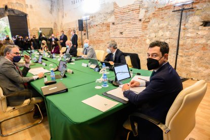 Juanma Moreno sonríe a Juan Sánchez, fotógrafo de LA VOZ, antes del comienzo del Consejo de Gobierno.