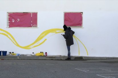 Tati realizando uno de sus murales para los colegios.