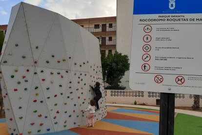 Dos niños juegan en el rocódromo.