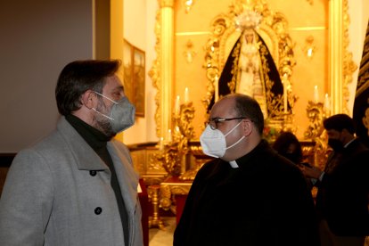 El hermano mayor de Estudiantes y el párroco de San Agustín con la imagen de la Virgen del Consuelo al fondo.