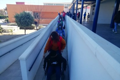 Alumnos comprobando lo que supone desplazarse en silla de ruedas.