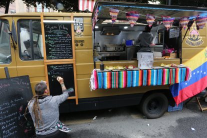 En el satnd de Venezuela ultimando la carta de comidas en la pizarra.