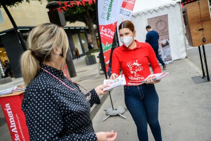 Una azafata reparte folletos informativos.