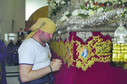Uno de los costaleros de la Señora, concentrado rezándole antes meterse en el paso.