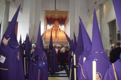 Nazarenos preparados para salir a la calle y la Virgen al fondo.