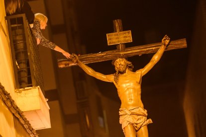 Una mujer toca la imagen del Cristo del Perdón instantes después de su salida de la iglesia de San Ildefonso.