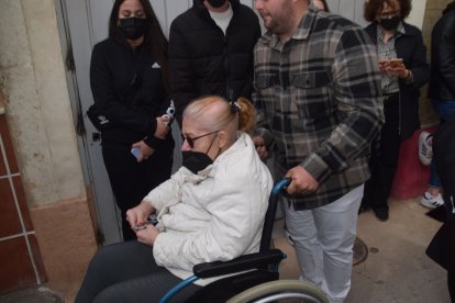 Una devota de Pescadería en su silla de ruedas con una estampa del Cristo del Mar que le entregó el capataz.