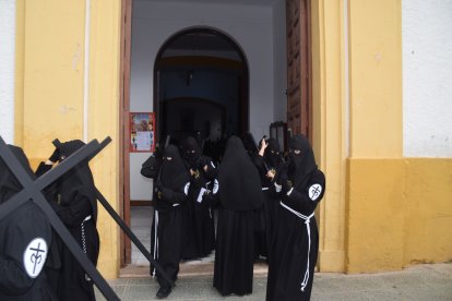 Nazarenos accediendo a la calle con la cruz a cuestas.