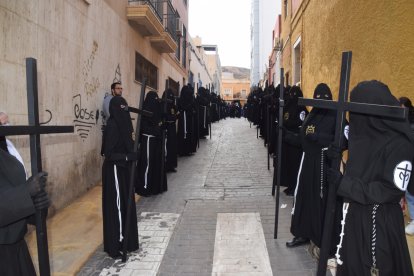 Nazarenos con las cruces en calle Corbeta, preparados para partir hacia el centro de la ciudad.