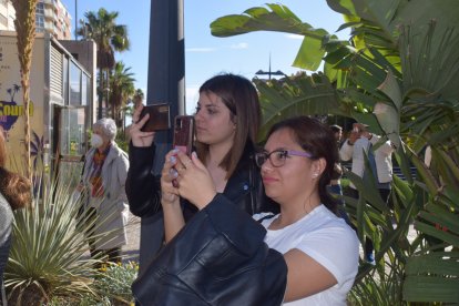 Tiana Raquel y Angus, recogiendo con sus móviles el paso de palio de la Virgen.