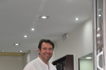 El peluquero Camilo Ferrón, trabajando a pie de calle en Altamira mientras a unos metros transcurría el desfile procesional.
