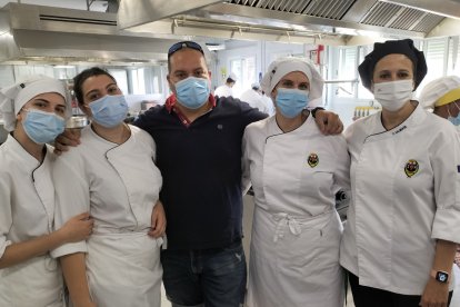 El profesor de pastelería, José Ángel Mena, con cuatro de sus alumnas, Paqui, Lola. Alba y Alicia, preparando postres para la imposición de bandas del día siguiente.
