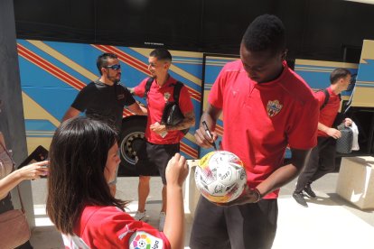 Umar Sadiq firmando un balón a una peque aficionada.