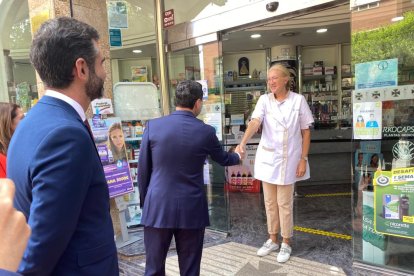 Juanma Moreno saluda a una farmacéutica.