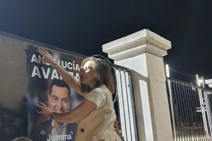 Maribel Sánchez, pegando un cartel de Juanma Moreno.