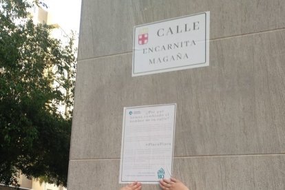 Una integrante de la formación de izquierdas pega uno de los carteles.