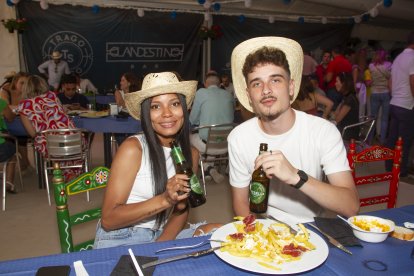 Una pareja degusta una cerveza bien fría con huevo frito, patatas y jamón,