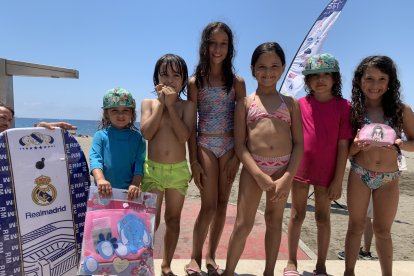 Algunos niños con regalos tras las actividades a pie de playa.