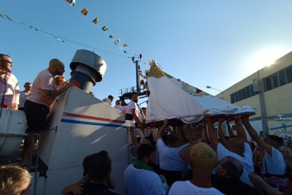 Instante en el que la Virgen del Carmen es subida a la embarcación.