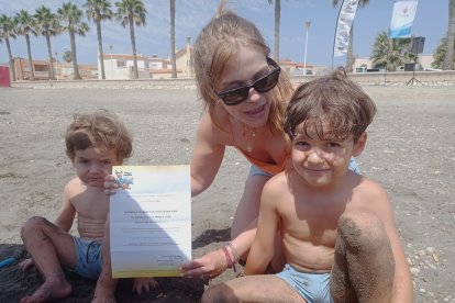 Esmeralda y sus dos hijos con una entrada para el parque acuático de Almuñecar.