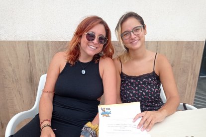 Clara con su prima y el bono familiar para visitar el parque acuático Aquatropic.