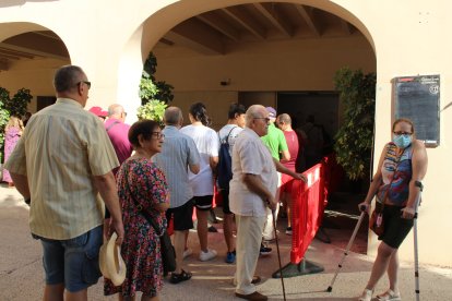 La gente en la puerta donde se reparten los abanicos en la plaza.