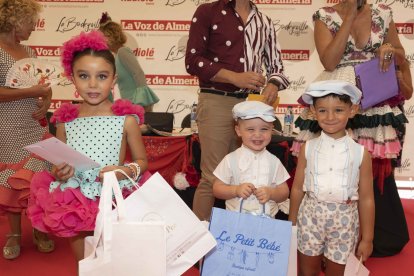 Los tres pequeños posando con sus regalos.