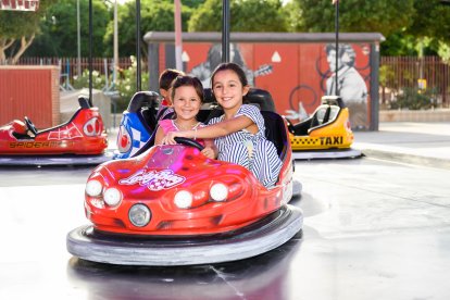Las hermanas  Ariana y Alma en los coches de choque.