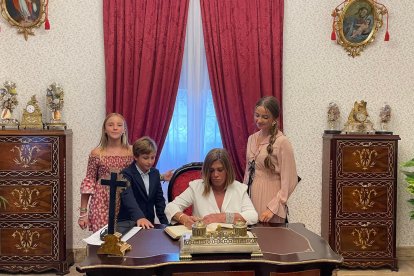 Pilar Alfonso Rodríguez firmando en el libro de honor del Santuario acompañada por sus nietos.