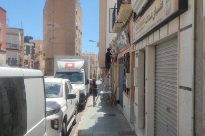 Operarios montando un rótulo en un establecimiento.