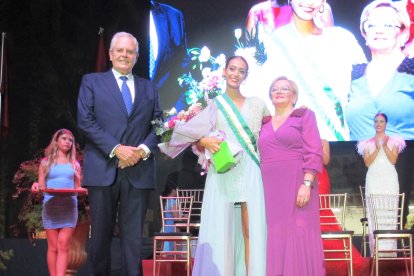 Una de las damas juveniles recibe la banda y el ramo por parte de las autoridades locales.