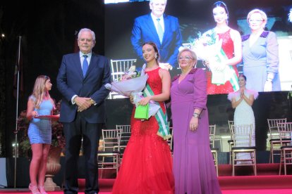 Una de las damas juveniles recibe la banda y el ramo por parte de las autoridades locales.