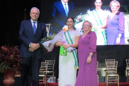 Una de las damas juveniles recibe la banda y el ramo por parte de las autoridades locales.