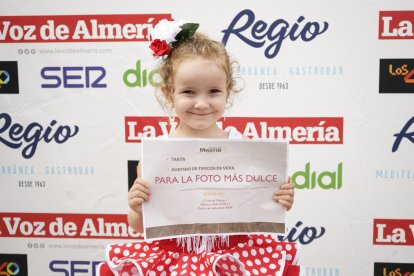 La joven afortunada posa junto a su premio, por ser la más dulce de las Fiestas.