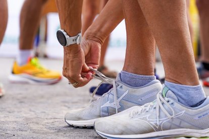 Un participante atándose las zapatillas para competir.