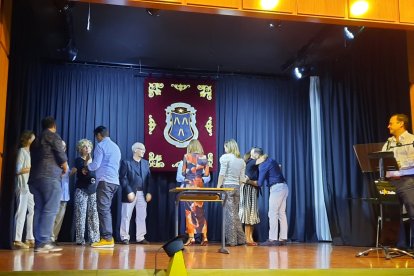 Juan Uribe, de la Asociación de Antiguos Alumnos (dcha.) fue llamando a los alumnos para la imposición de insignias.