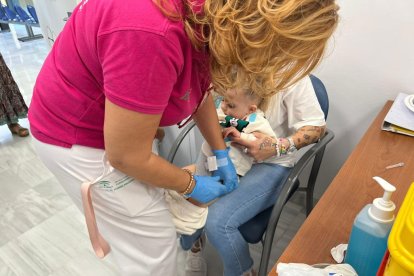 Los sanitarios reciben la ayuda de los padres para vacunar a los pequeños.