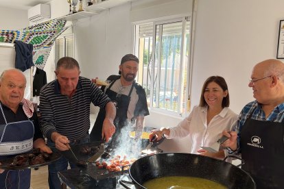 Miembros de la AA.VV La Reja, elaborando las migas y asando morcillas en la plancha.