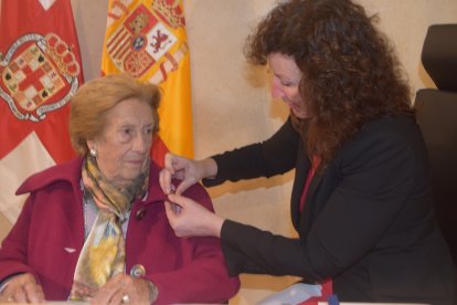 María del Mar Vázquez, imponiendo el escudo de oro a María Aguirre.