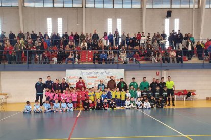 Los equipos posando en la pista con los aficionados.