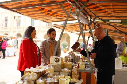 El concejal, Carlos Sánchez, inaugurando la VIII Feria del Queso en la Plaza Vieja, acompañado por una de las organizadoras, Yolanda Robles, degustando los quesos manchegos Medina.