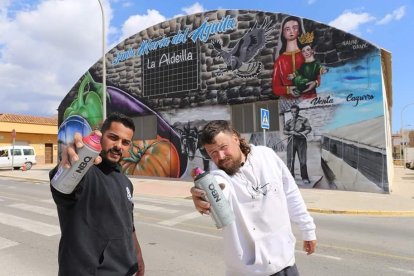 Los artistas urbanos Dank y Nauni posan delante del mural.