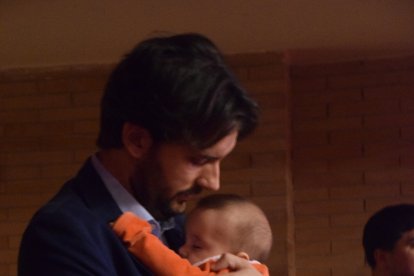 Un padre arropando a su hija durante el acto.