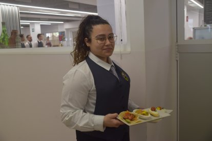 Una alumna sirviendo los aperitivos en sala.